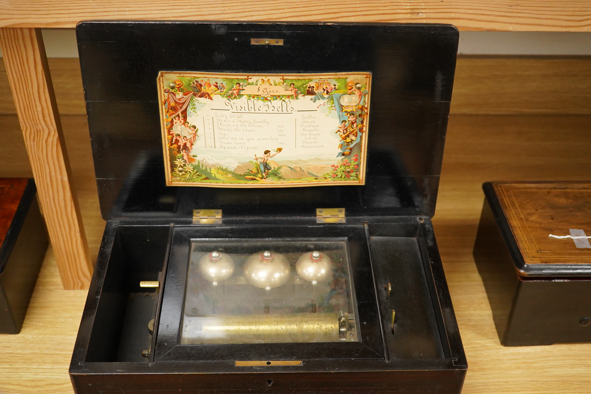 A mid-19th century inlaid and ebonised rosewood Swiss cylinder music box playing eight airs on a cylinder and three bells, card label to the inside of the lid listing the airs, complete with all teeth to the comb, cylind